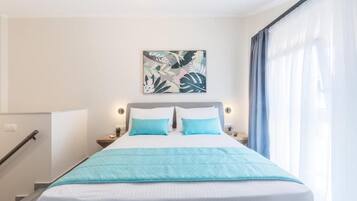 A hotel room with a bed, a nightstand, a wall-mounted artwork, and a staircase.
