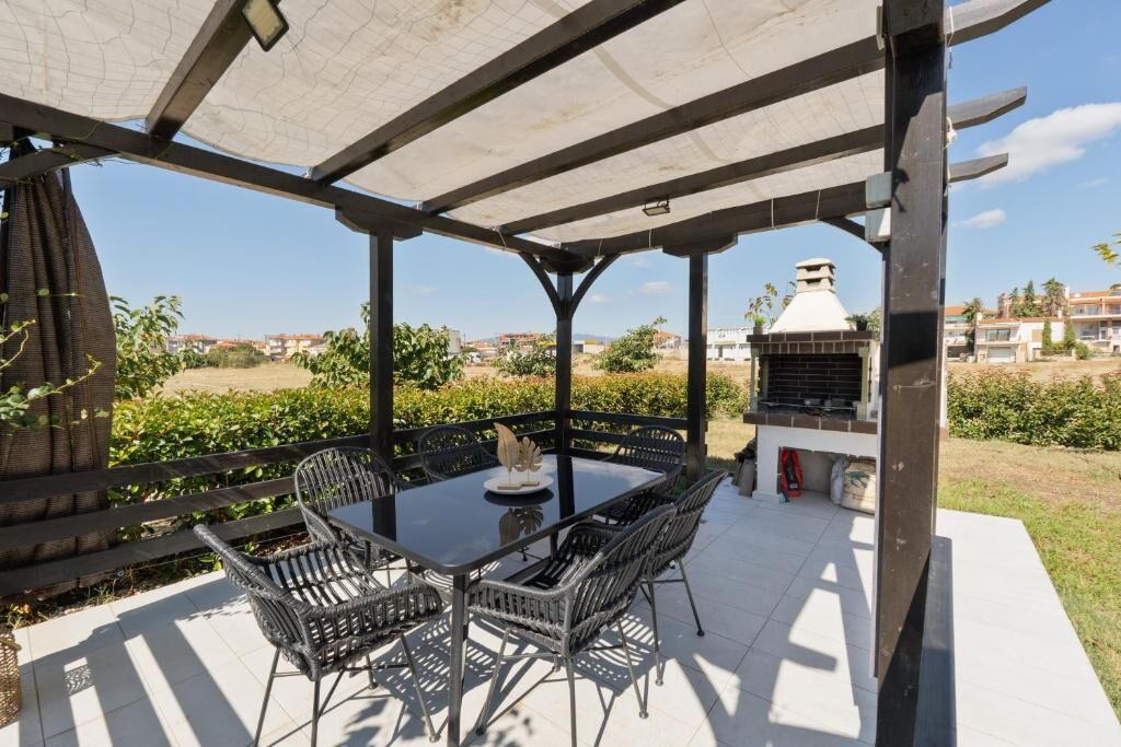 Une terrasse extérieure avec une table et des chaises, un barbecue et une vue sur les environs.