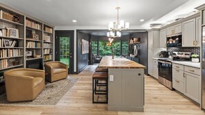 Een moderne keuken met een centraal eiland, inbouwkasten en een eethoek met lederen stoelen.