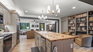 Een moderne keuken met een centraal eiland, inbouwapparatuur en een eethoek met uitzicht.