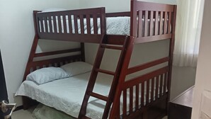 Een stapelbed met een ladder, een bureau en een deur.