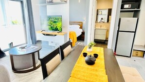 A modern living room with a dining area, a kitchen, and a bedroom. - Tropical Ocean Breeze Retreat Steps from Beach & Lagoon (Paje)