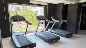A gym with treadmills, a stationary bike, and a rowing machine.