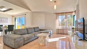 A modern living room with a sectional sofa, a coffee table, and a flat-screen TV. - Dionis apartment - 3 bedroom apartment with shared pool in a quiet neighborhood (Zadar)
