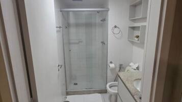 A bathroom with a shower, toilet, and sink.