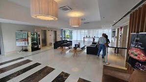 A spacious lobby with a black leather sofa, a coffee table, and a large wooden pendant light. - Flats Premium com vista Incrível no hotel Vision (Brasília)