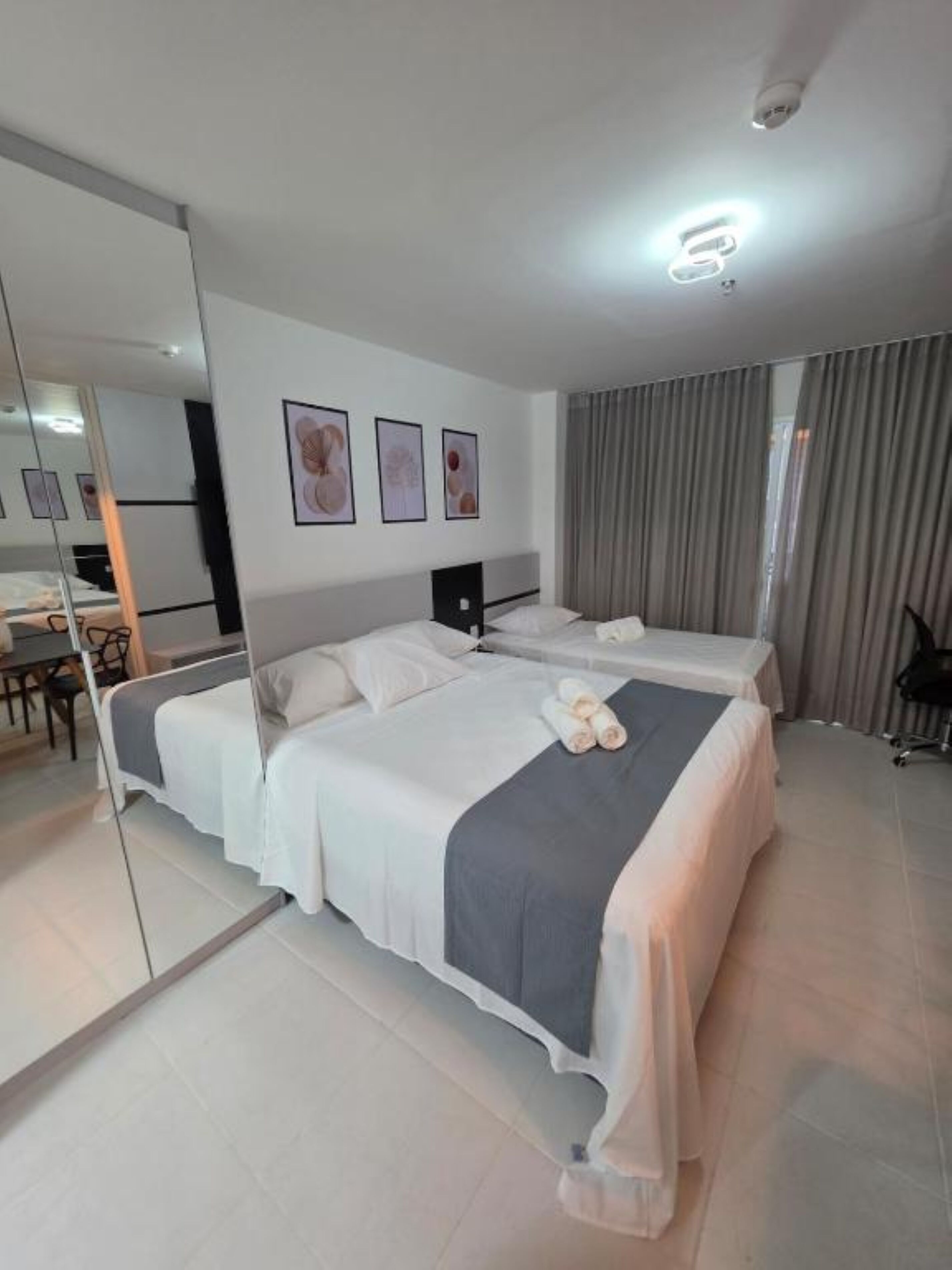 Ein Hotelzimmer mit zwei Betten, einem Schreibtisch und einem Stuhl.