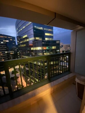 A balcony with a view of modern buildings at dusk.