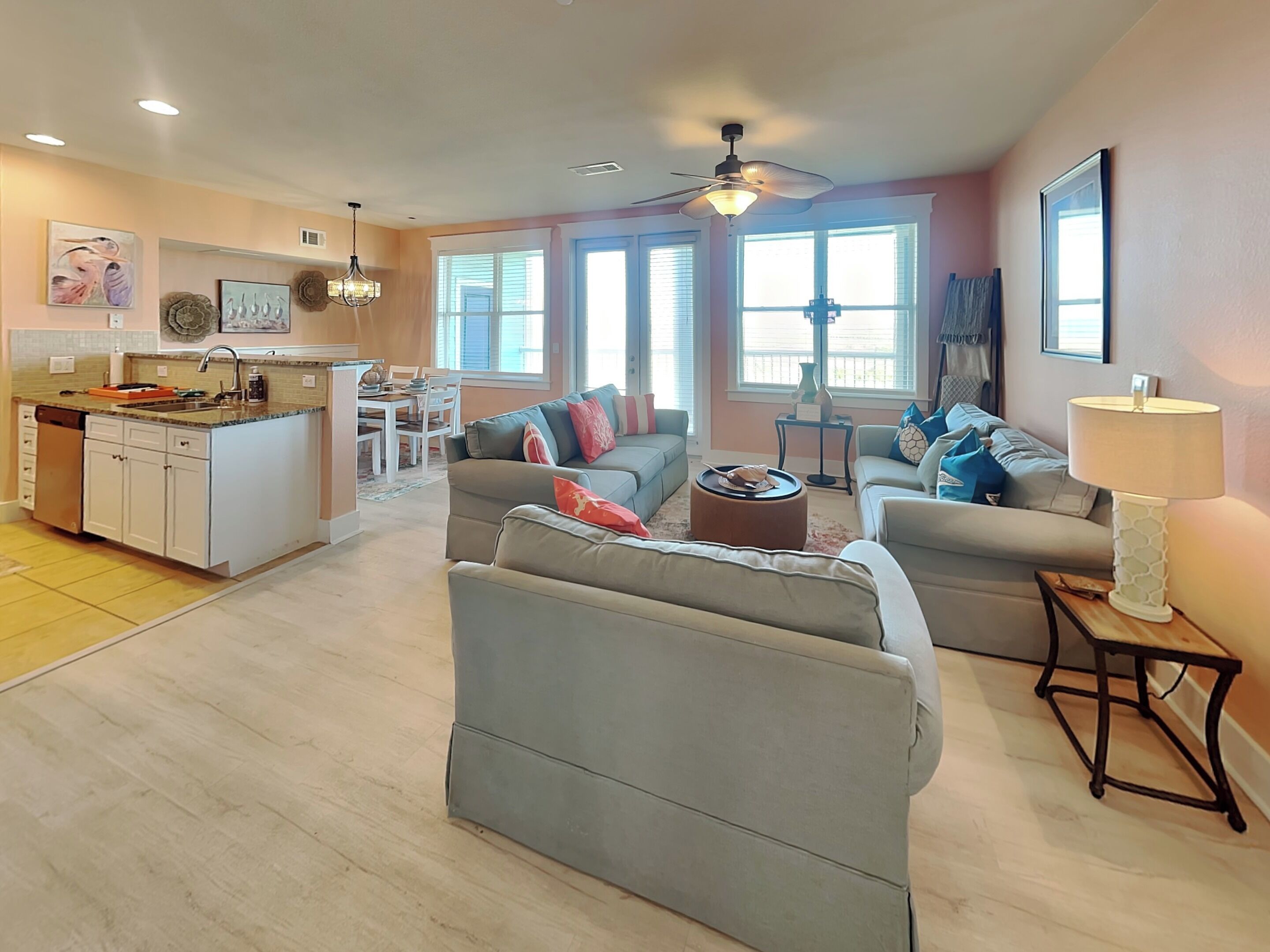 A spacious living area with a kitchen, dining area, and a large window providing natural light.