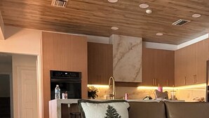 Un salon moderne avec un canapé, une table basse et un plafond en bois.