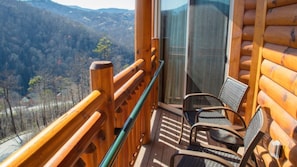 A wooden balcony with a glass railing overlooking a mountainous landscape. - Deluxe King 1BR at Westgate Smoky Mountain – Water Park & Mountain Views (Gatlinburg)