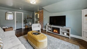 Ein Wohnzimmer mit Kamin, Fernseher und einer Couch.