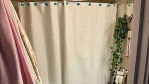 Een badkamer met douchegordijn, toilet, wastafel en een badmat.