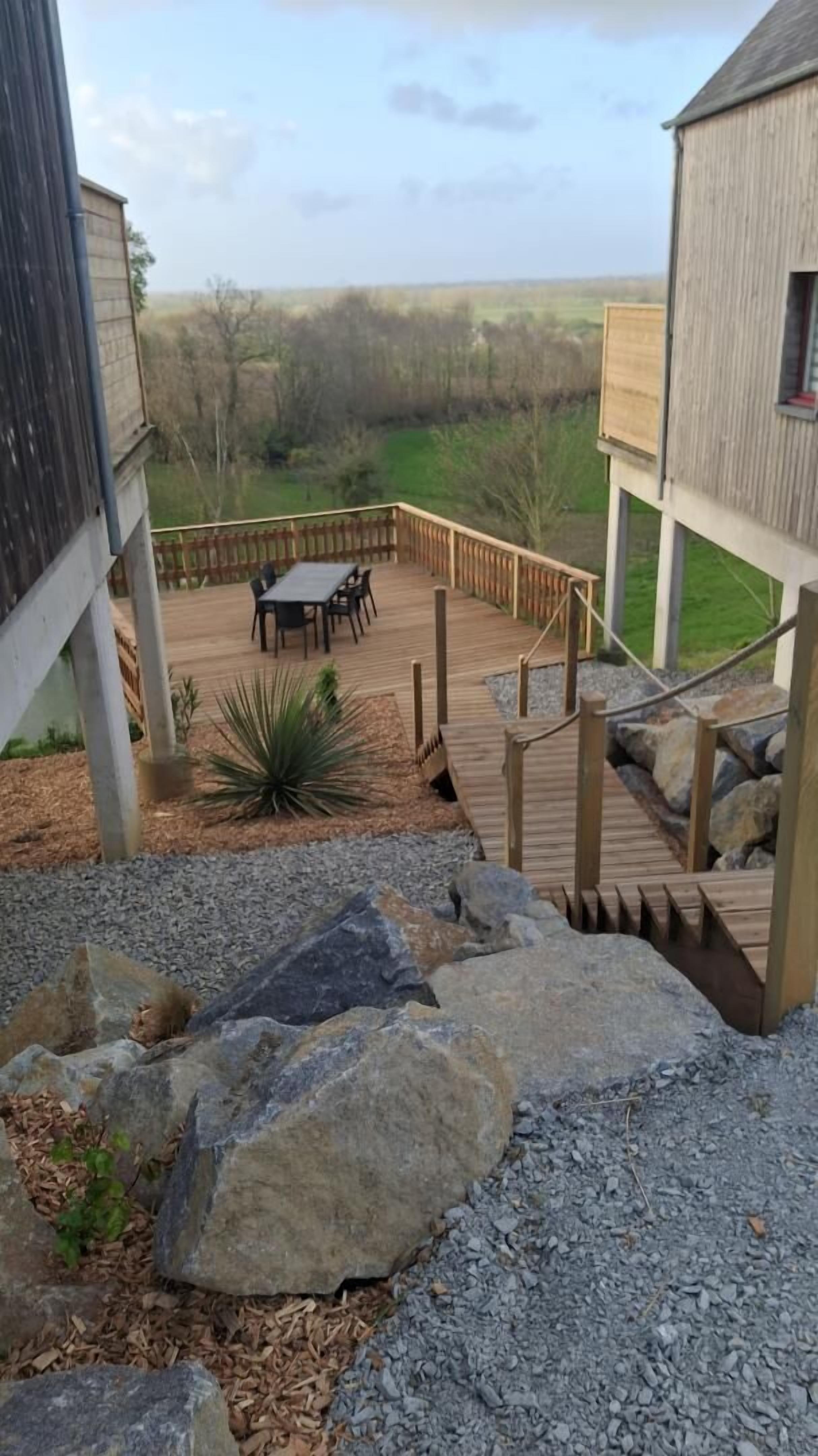 Una terrazza con mobili da esterno, un vialetto in pietra e vista sul paesaggio circostante.