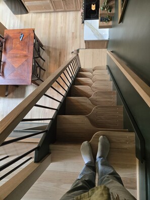Modern wood staircase with sleek railings and open kitchen below - Reconnect with nature and family in this one-of-a-kind stay at the Tableview. (Pickens)