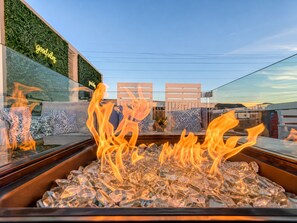 A fire feature with seating and a green wall with a neon sign. - Pink Vibes! Hot Tub + Rooftop Views  Sleeps 16 (Nashville)