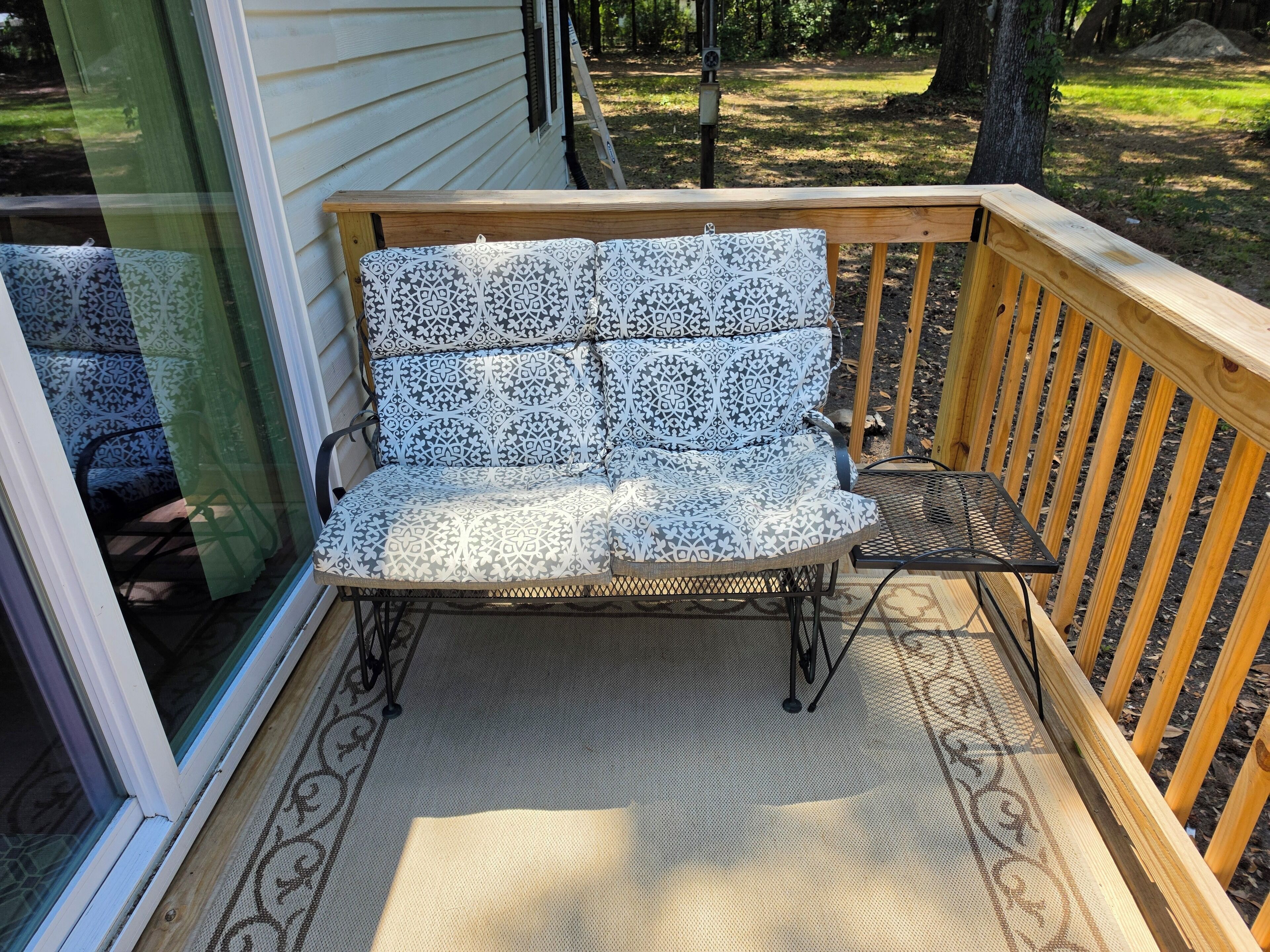 A wooden deck with a bench and a small table.