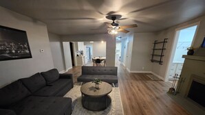 A living room with a dark sofa, a round coffee table, and a ceiling fan. - Quiet 2 Bedroom Escape Steps from Downtown Joliet (Joliet)