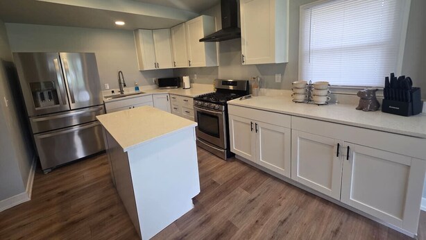 A modern kitchen with stainless steel appliances, white cabinetry, and a central island. - Quiet 2 Bedroom Escape Steps from Downtown Joliet (Joliet)