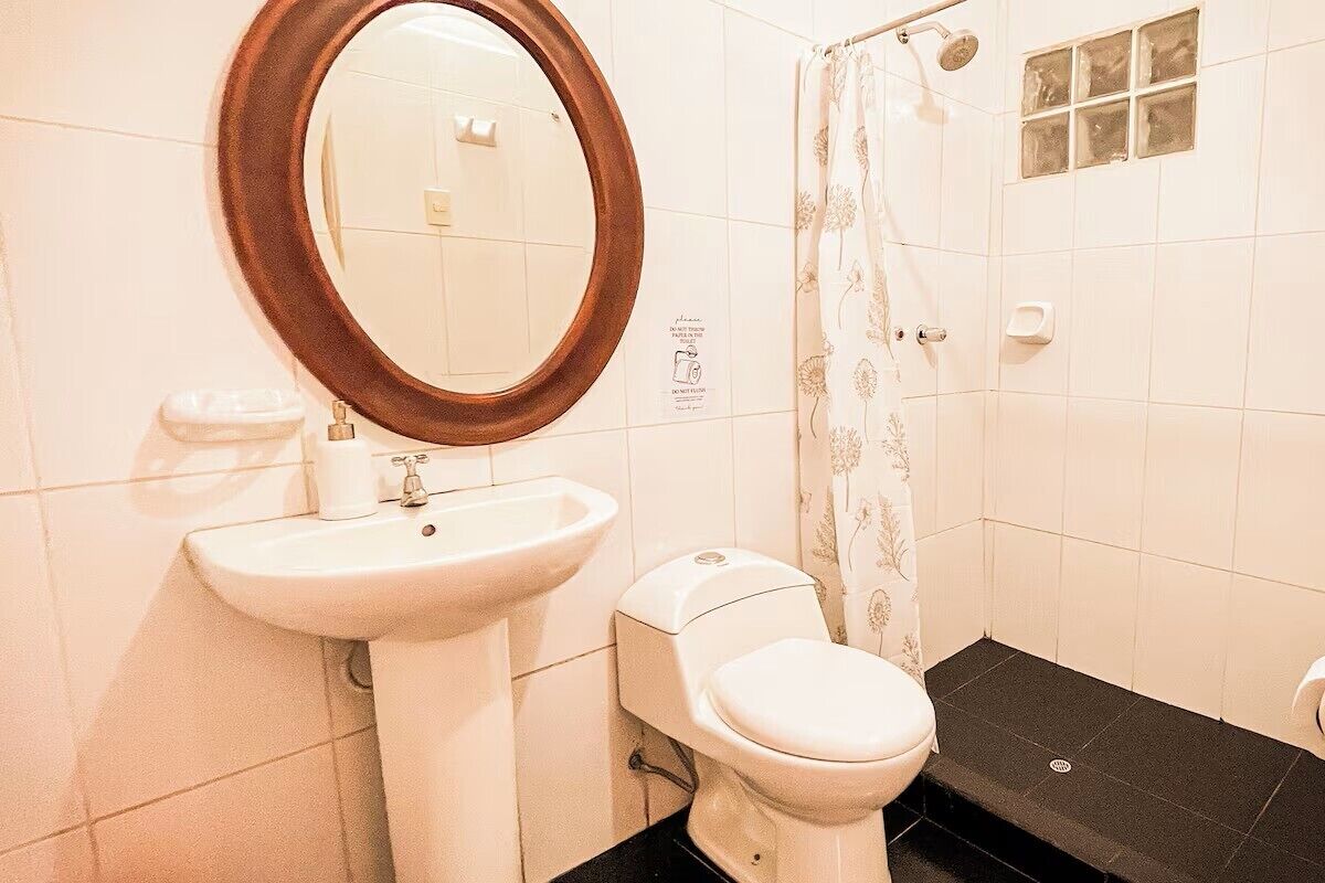 Un baño con lavamanos, inodoro y cortina de ducha.