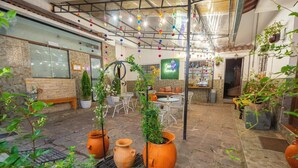 An indoor patio area with stone flooring, terracotta pots, and potted plants. - Casona de San Agustin (Cusco)