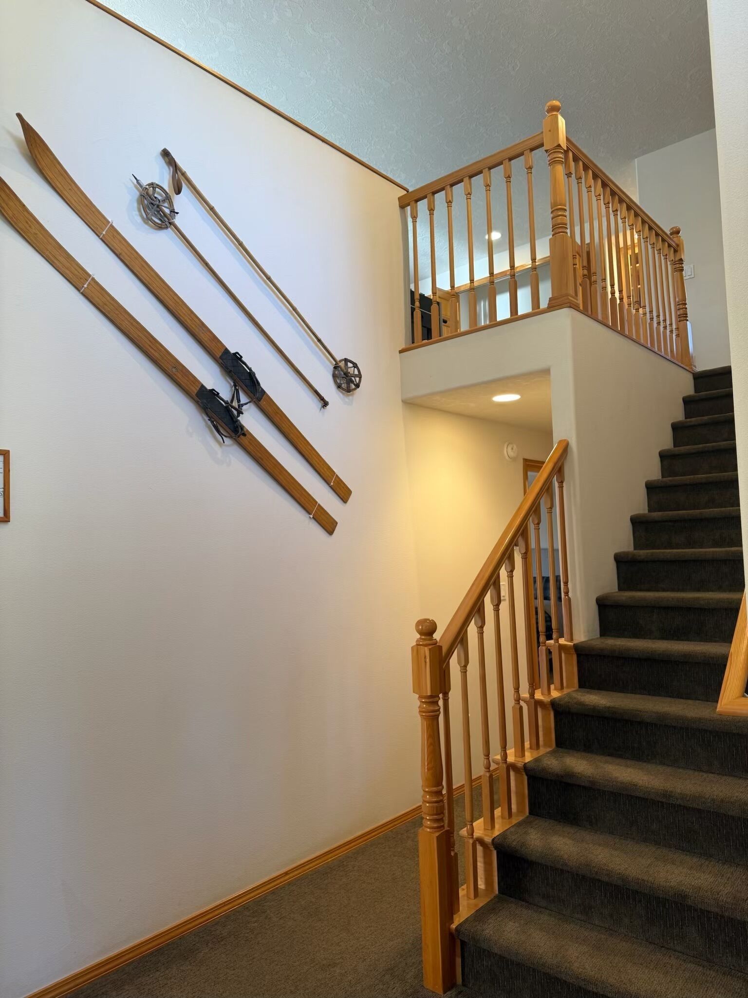 A staircase with wooden railings and carpeted steps.