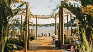 A beachside walkway leading to a wooden gazebo with benches and tables, overlooking a body of water. - Barlume Beach Montauk (Montauk)