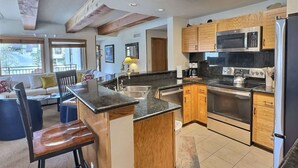A modern kitchen with a central island, stainless steel appliances, and wooden cabinetry. - The Plaza 239 | Walk to CBMR Lifts | 2 Hot Tubs+Sauna | 3BR Sleeps 8 (Crested Butte)
