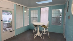 A room with a white table and chairs, a door with a view, and a skylight. - Little oasis  2-bedroom house in fantastic St. Petersburg with AC (St. Petersburg)