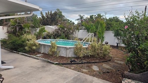 A backyard with a swimming pool surrounded by various plants and a white fence. - Little oasis  2-bedroom house in fantastic St. Petersburg with AC (St. Petersburg)