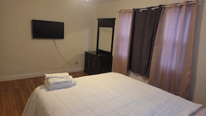 A bedroom with a bed, a TV mounted on the wall, a mirror, and a curtain. - Little oasis  2-bedroom house in fantastic St. Petersburg with AC (St. Petersburg)