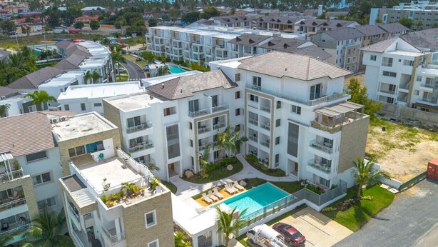 A multi-story residential building with balconies, a swimming pool, and a view of the ocean. - Modern Studio Pool Coral Azul Estrella Dominicus (Dominicus)