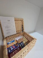 A wooden basket with a menu and snacks inside.