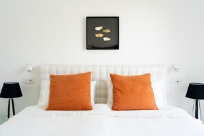 A bed with white bedding and two orange pillows, a black framed artwork above it, and two black lamps on either side. - Villa De Boer, brand new amazing seafront in Amalfi coast, private pool and garden (Piano di Sorrento)