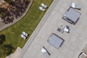 An aerial view of a rooftop with multiple lounge areas, a pathway, and a small garden area. - Villa De Boer, brand new amazing seafront in Amalfi coast, private pool and garden (Piano di Sorrento)