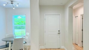 A room with a dining table, chairs, a white door, and a ceiling fan. - Stylish Comfort in Englewood 3BR 2BA, Great Location (Englewood)