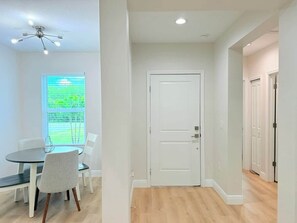 A room with a dining table, chairs, a white door, and a ceiling fan. - Stylish Comfort in Englewood 3BR 2BA, Great Location (Englewood)