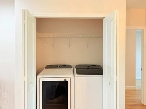 Une buanderie équipée de deux machines à laver et d’un étendoir.