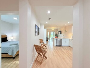 A modern hotel room with a bed, a desk, and a kitchenette. - Stylish Comfort in Englewood – 3/2, Great Location (Englewood)