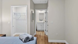 A bedroom with a bed, a walk-in closet, and a bathroom with a sink and mirror. - Relax in Englewood 3BR 2BA Home Close to Beaches (Englewood)