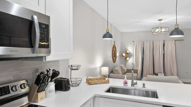 A modern kitchen with a built-in microwave, stainless steel appliances, and a white countertop. - Relax in Englewood 3BR 2BA Home Close to Beaches (Englewood)