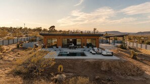 A modern house with a pool, outdoor seating, and a desert landscape. - Desert Haus · Pool, Hot Tub, Fire Pit, Views (Joshua Tree)