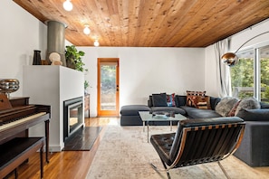 A modern living room with a piano, sofa, and a glass coffee table. - Spacious 3BR/ 2BA Topanga Home – Nature Retreat w AC and Laundry (Topanga)