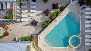 An aerial view of a hotel with a swimming pool, lounge chairs, and outdoor seating areas. - Harbour House #212 "Shore Thing" (Fort Myers Beach)