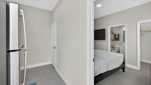 Un dormitorio con cama, armario y espejo.