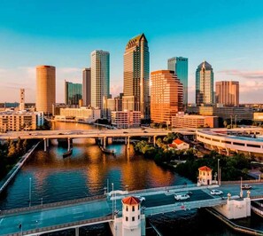 Eine moderne Skyline mit Hochhäusern, einem Fluss und einer Brücke.