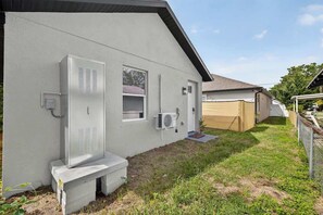 A residential building with a grey exterior, a white door, and a small window. - Brand-New 1BR | Minutes to Tampa’s Top Attractions (Tampa)
