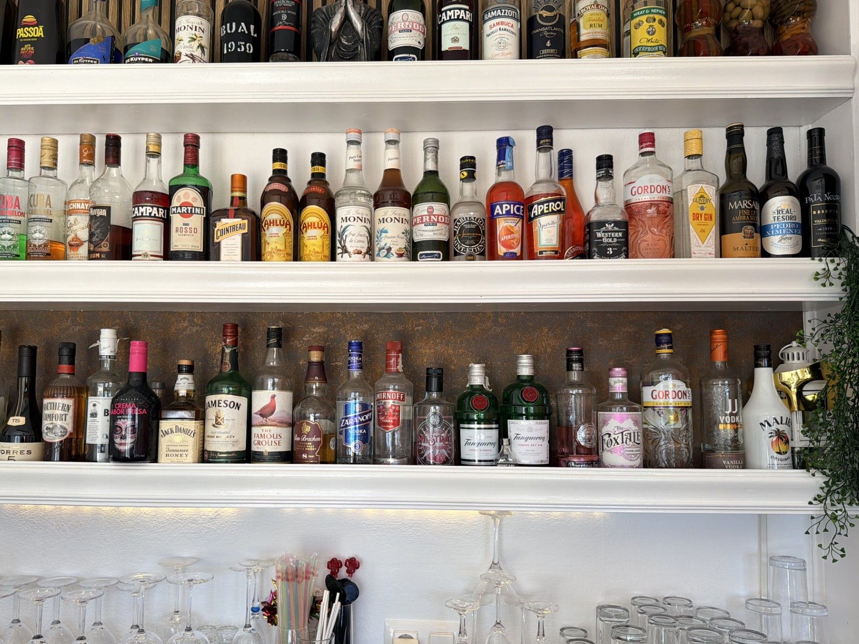 Un bar con scaffali pieni di diverse bottiglie di liquore.