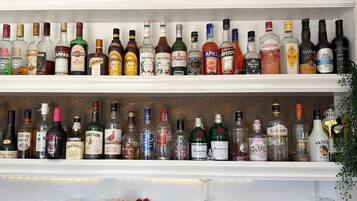 Un bar doté de plusieurs étagères remplies de différentes bouteilles d’alcool.