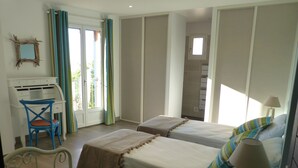 Une chambre avec deux lits, un bureau et une chaise.